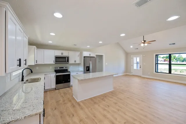a big room with wooden floor and bathroom view