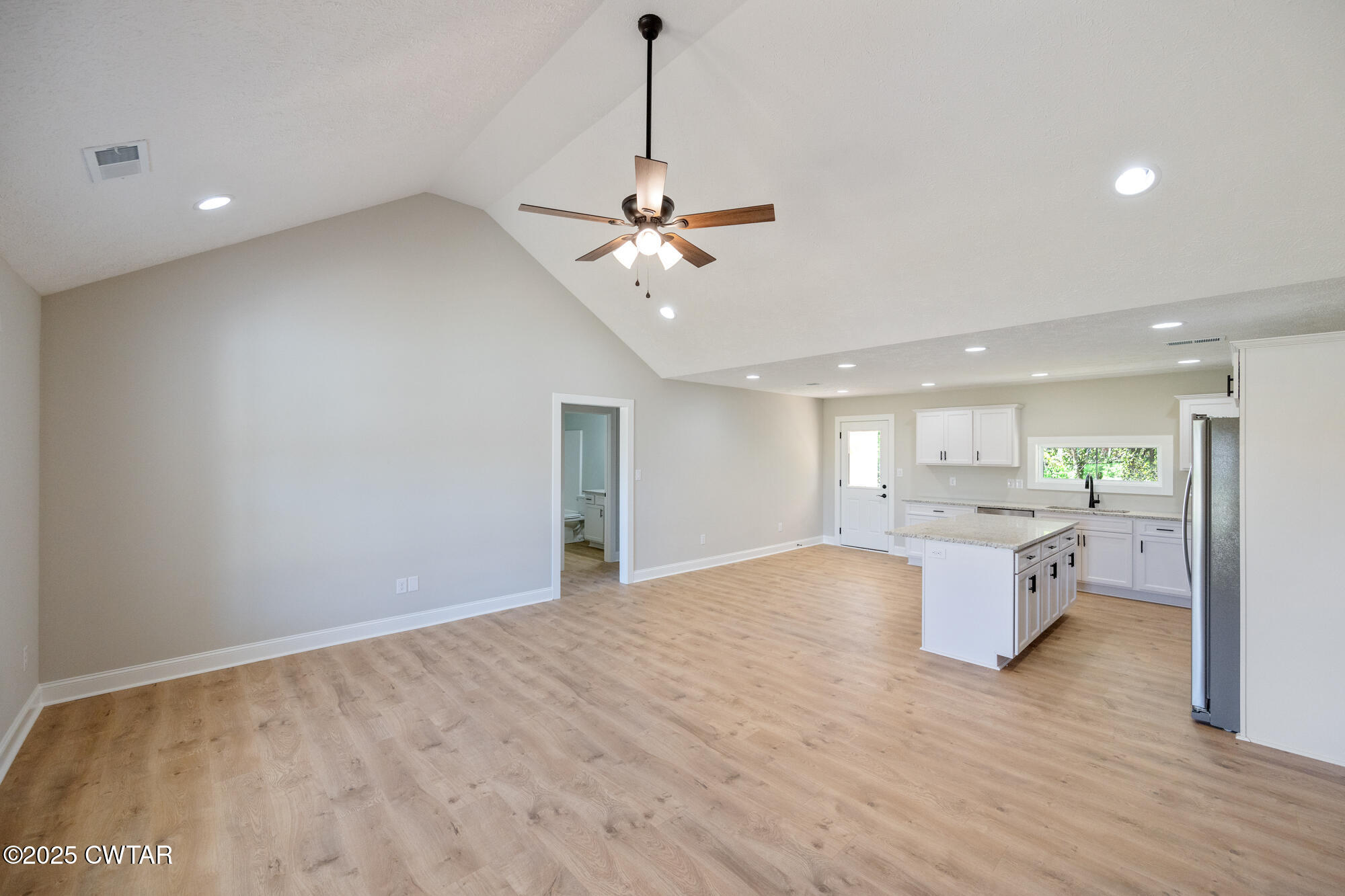 90 Derek Drive Lexington, TN 38351 - Photo 10 of 32 a view of an empty room and kitchen view with wooden floor