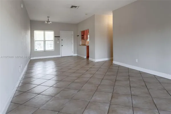 an empty room with windows and cabinet