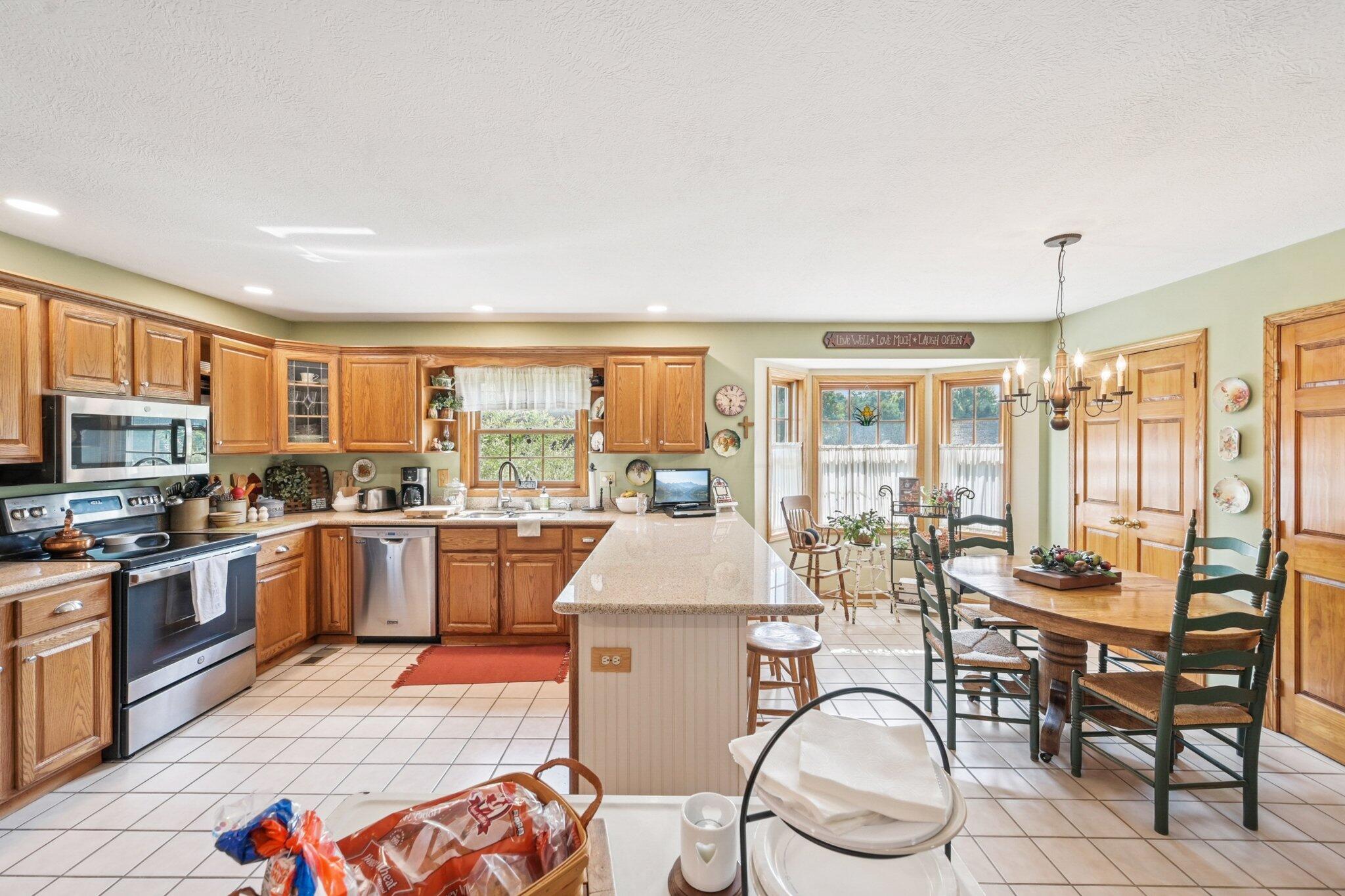 7700 Plumb Road Galena, OH 43021 - Photo 56 of 94 Wide-angle view of the kitchen and eat-in area showcasing an oversized island, stainless steel appliances, and beautiful natural light.
