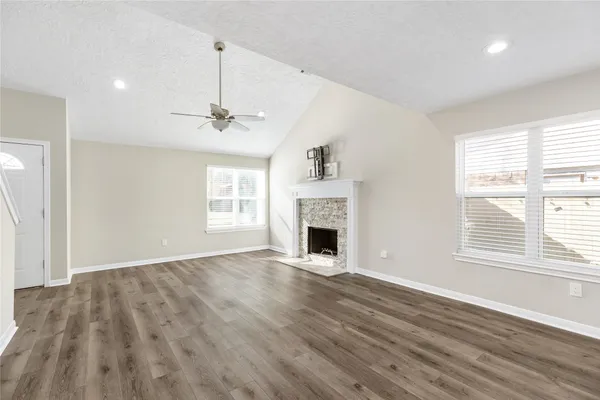 a view of an empty room with window and wooden floor