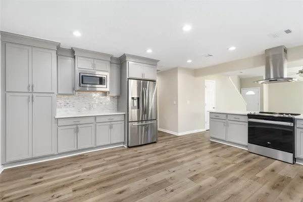 a view of a kitchen with wooden floor and a window