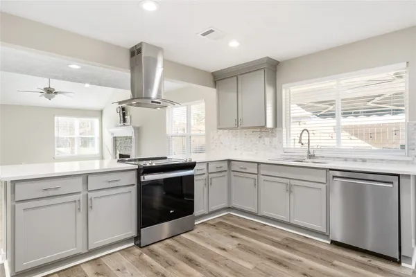a large kitchen with a refrigerator and a stove top oven