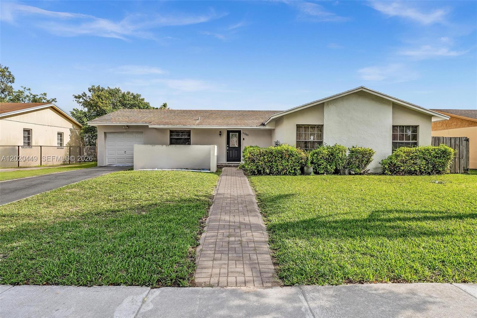 11061 Southwest 163rd Street Miami, FL 33157 - Photo 1 of 42 a front view of house with yard and green space