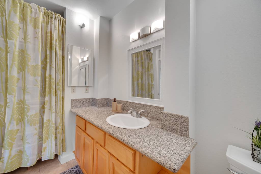 4156 Rice Street, Unit 107 Lihue, HI 96766 - Photo 16 of 29 a bathroom with a granite countertop sink and a mirror