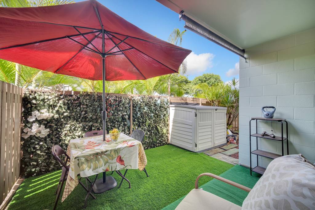 4156 Rice Street, Unit 107 Lihue, HI 96766 - Photo 21 of 29 a patio with a table and chairs under an umbrella