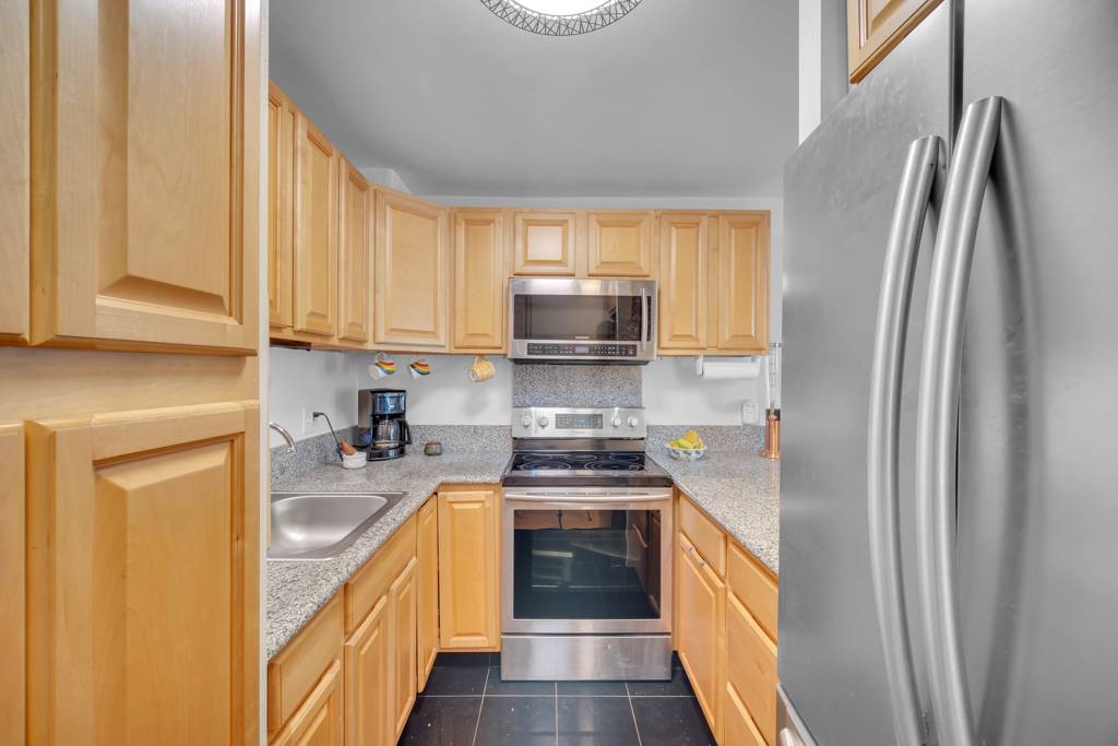 4156 Rice Street, Unit 107 Lihue, HI 96766 - Photo 6 of 29 a kitchen with stainless steel appliances a stove a sink and a refrigerator