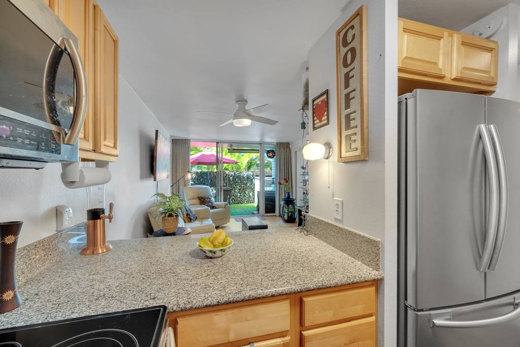 4156 Rice Street, Unit 107 Lihue, HI 96766 - Photo 8 of 29 a kitchen with stainless steel appliances granite countertop a refrigerator and a sink