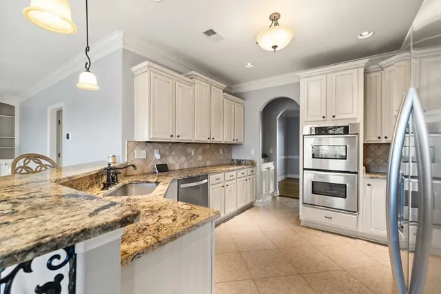 a kitchen with stainless steel appliances granite countertop a refrigerator and a stove top oven