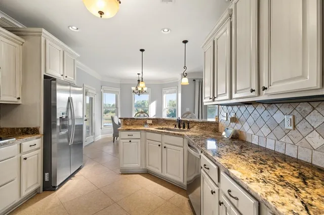 a kitchen with stainless steel appliances granite countertop a stove a sink and a refrigerator