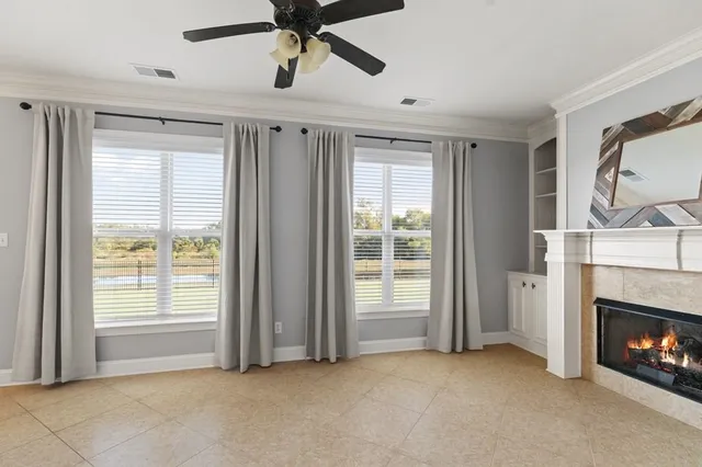 a view of an empty room with fireplace and a window