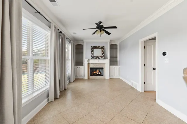a view of an empty room with a fireplace and a window