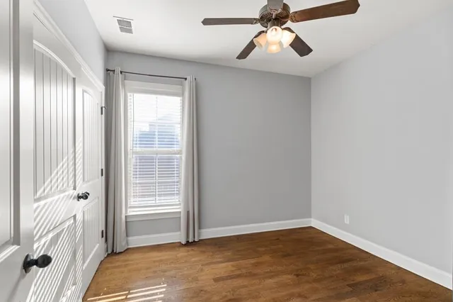 a view of a livingroom with a chandelier fan and windows