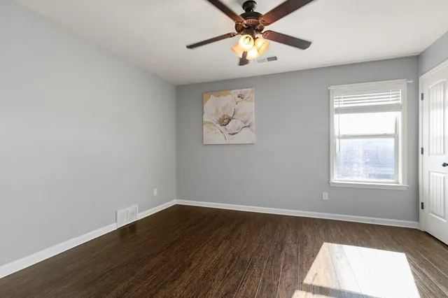 an empty room with a window and a fan