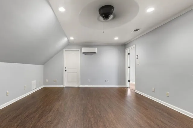 an empty room with wooden floor and a ceiling fan