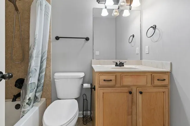 a bathroom with a sink mirror vanity and toilet