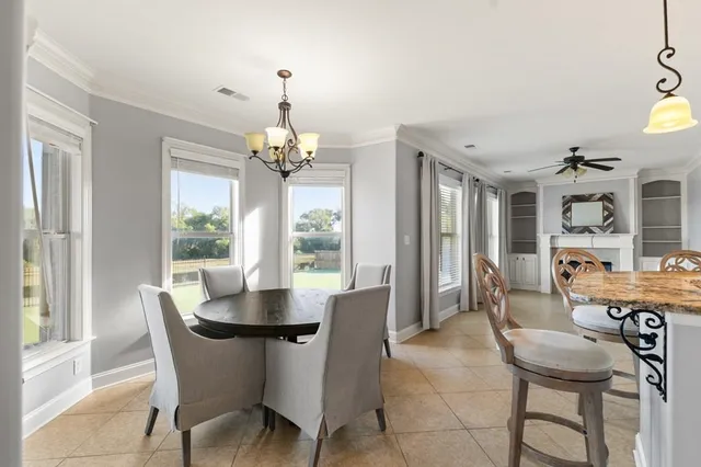 a dining room with furniture a chandelier and wooden floor