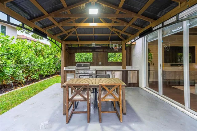 a patio with table and chairs and potted plants