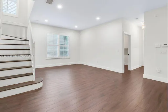 an empty room with wooden floors and window