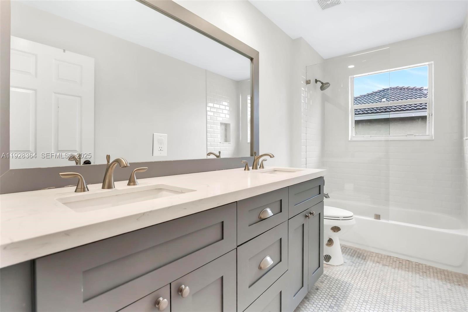 16437 Southwest 28th Street Miramar, FL 33027 - Photo 22 of 34 a bathroom with a double vanity sink mirror double and bathtub