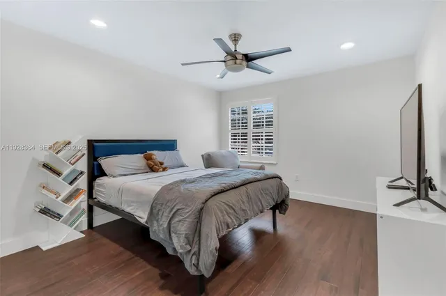 a bedroom with a bed a ceiling fan and a dresser