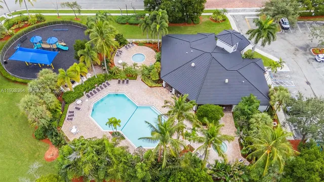 an aerial view of a house with a swimming pool a yard and a swimming pool