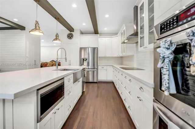 a large kitchen with stainless steel appliances sink a stove and cabinets