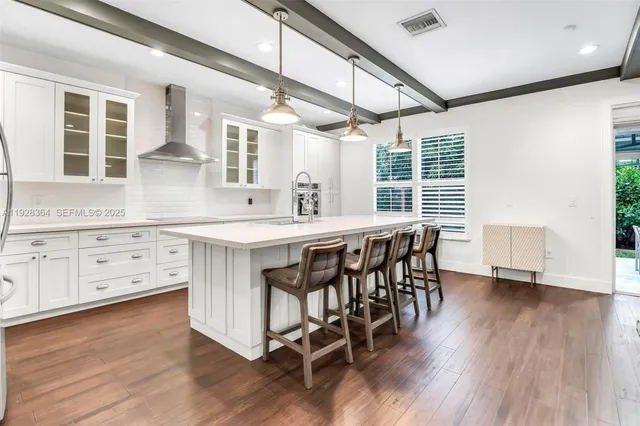 a kitchen with stainless steel appliances granite countertop a table chairs stove and wooden floor