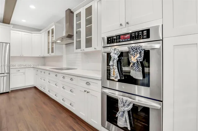 a kitchen with stainless steel appliances cabinets and a wooden floor