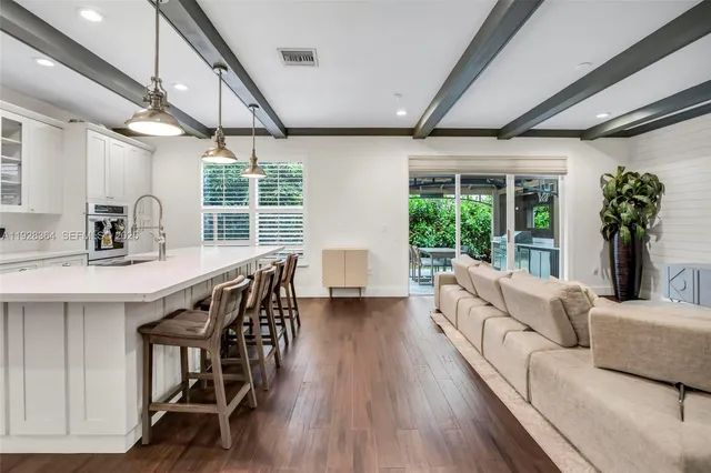 a living room with furniture wooden floor and a large window