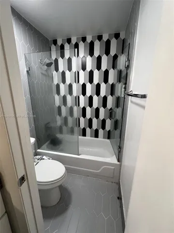 a white toilet sitting next to a bath tub