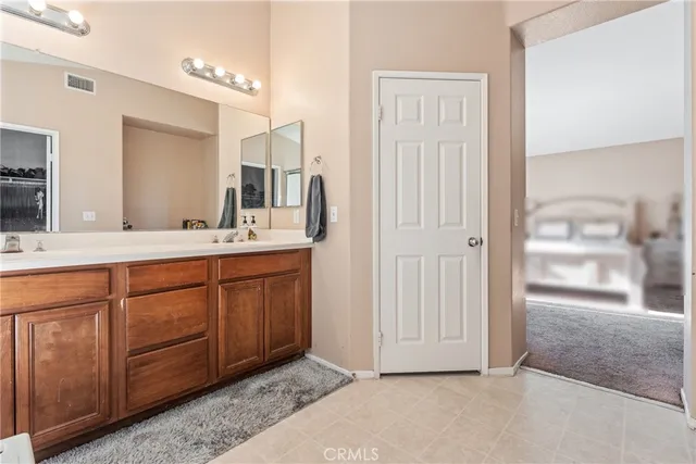 a spacious bathroom with a double vanity sink a mirror and a shower