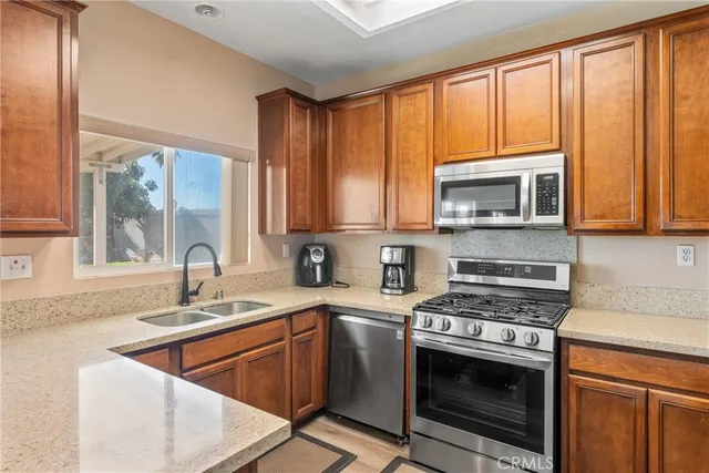 a kitchen with stainless steel appliances granite countertop a stove a sink and a microwave