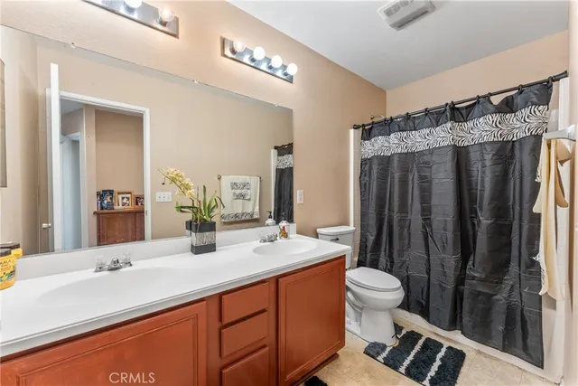 a bathroom with a double vanity sink toilet and shower