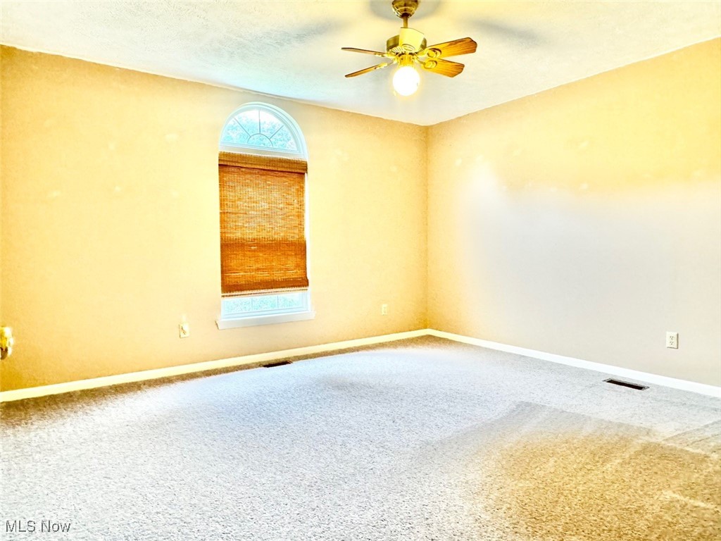 1467 Bennett Road Madison, OH 44057 - Photo 23 of 26 Carpeted empty room featuring ceiling fan and a textured ceiling