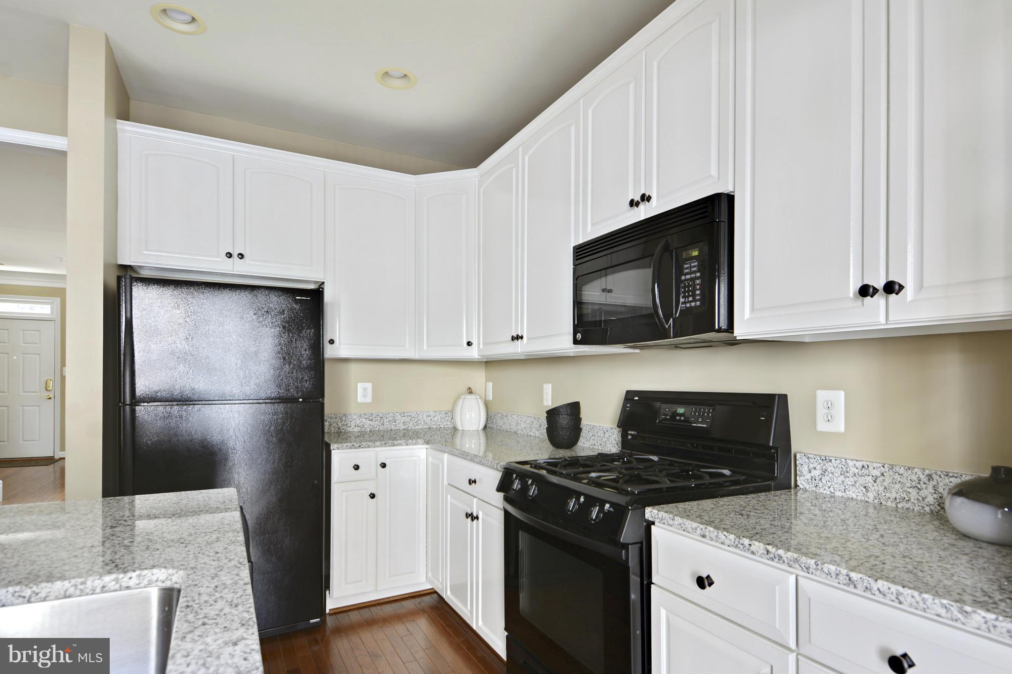 8523 2nd Avenue Silver Spring, MD 20910 - Photo 9 of 30 a kitchen with stainless steel appliances granite countertop a refrigerator stove a sink and dishwasher with wooden floor