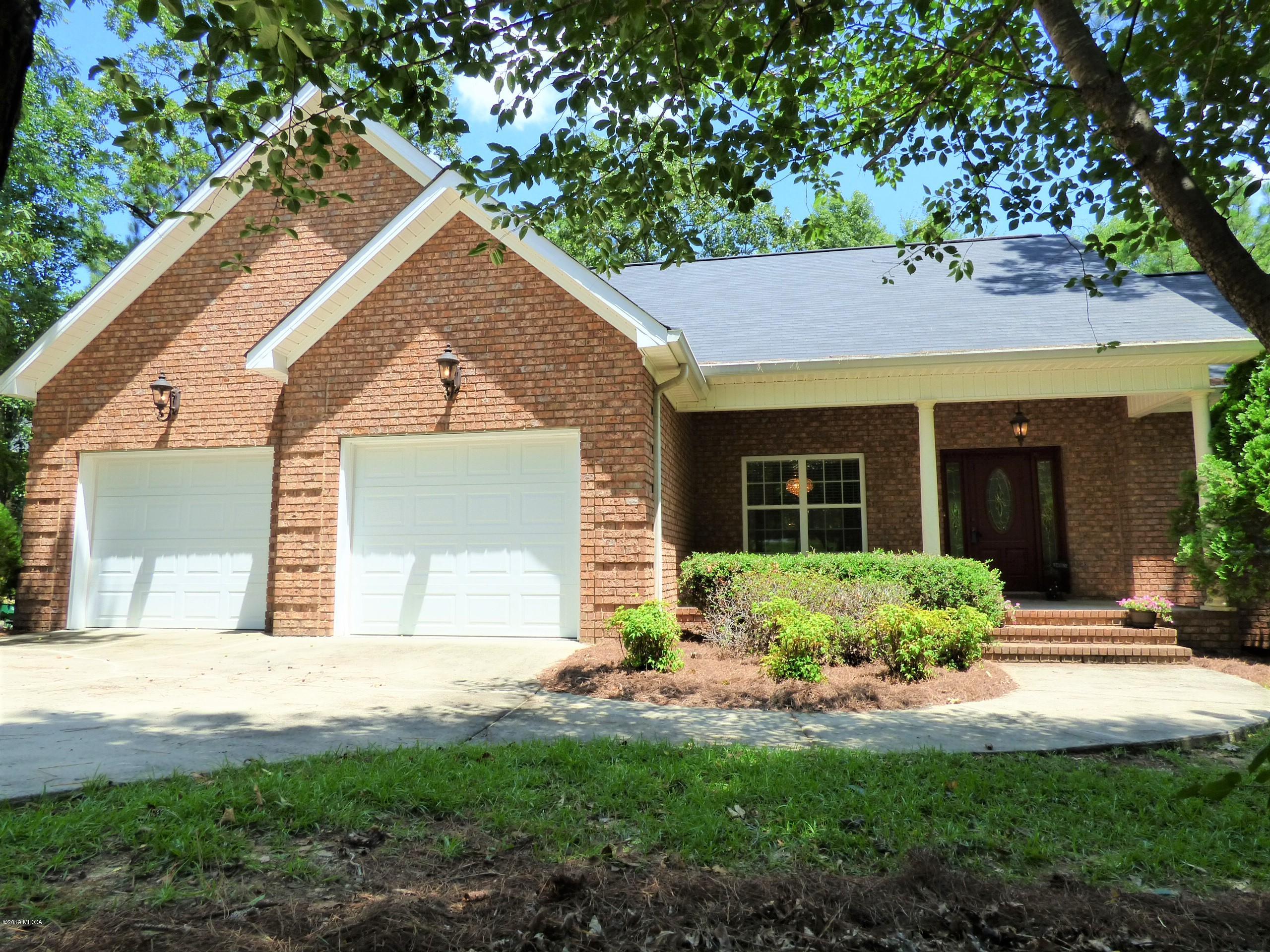 a front view of a house with a yard and potted plants