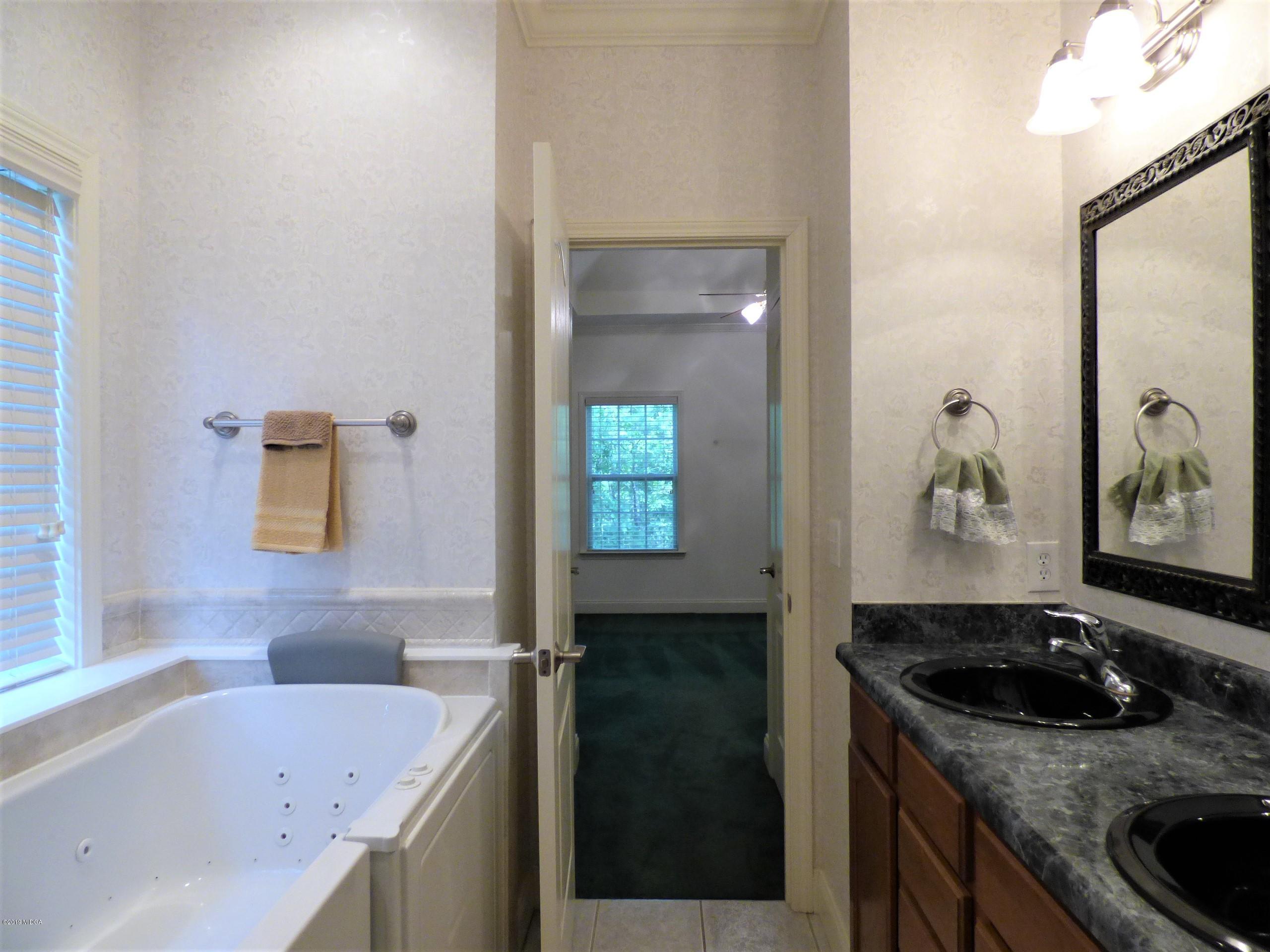 222 Ridge Point Way Macon, GA 31220 - Photo 14 of 19 a bathroom with a granite countertop sink a mirror and bathtub