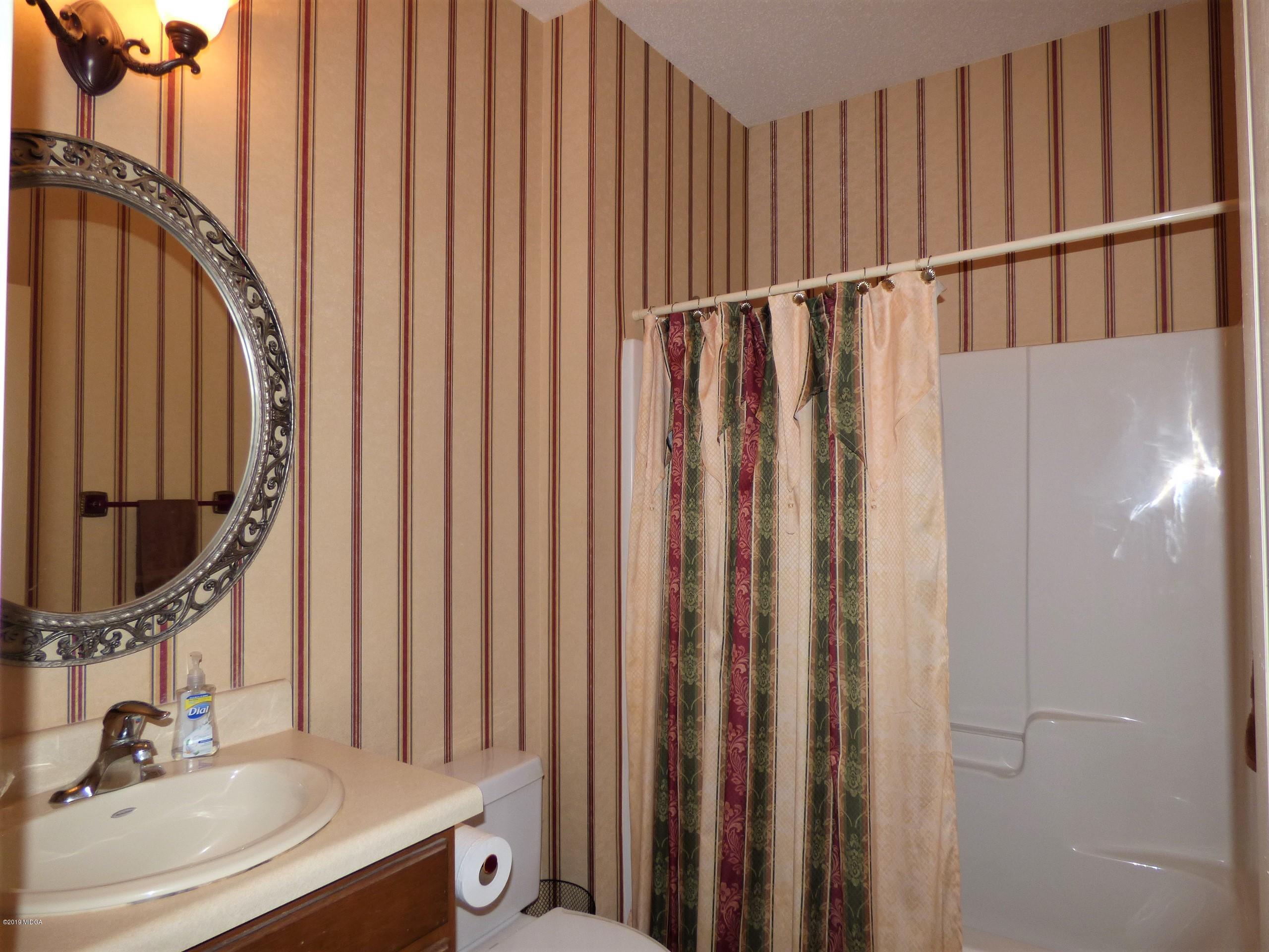 222 Ridge Point Way Macon, GA 31220 - Photo 7 of 19 a bathroom with a sink a mirror and a shower