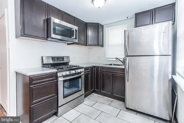 a kitchen with stainless steel appliances a refrigerator stove and microwave