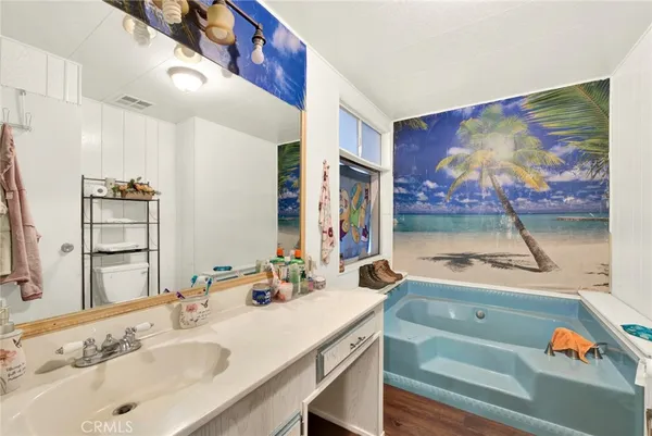 a bathroom with a tub sink and mirror