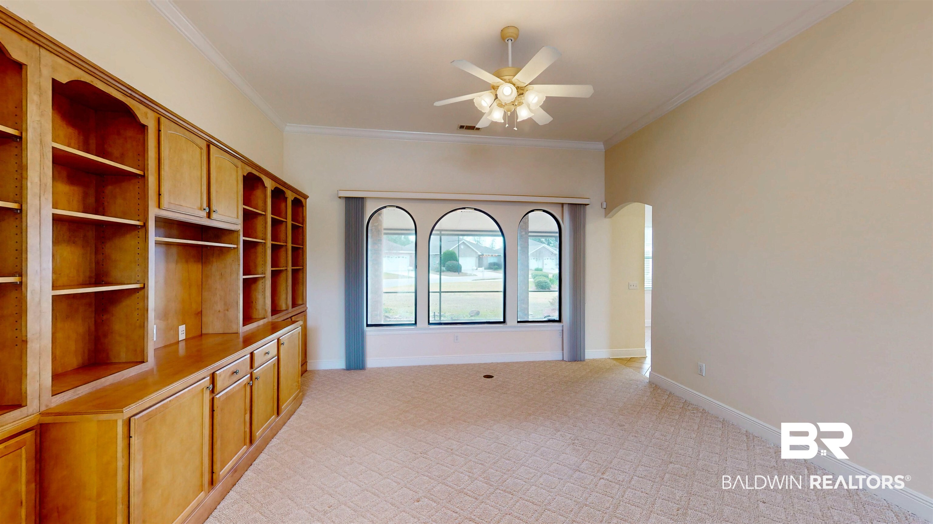 214 Hemingway Loop Foley, AL 36535 - Photo 6 of 67 Unfurnished room featuring crown molding, arched walkways, and a ceiling fan