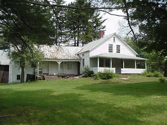a front view of a house with a garden and trees