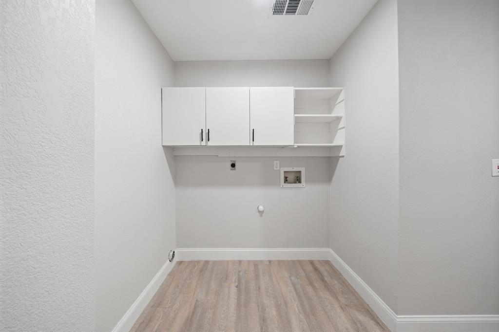 310 Valley Spring Drive Arlington, TX 76018 - Photo 12 of 24 Dedicated utility space featuring light wood-finish flooring, white baseboards, and neutral wall tones