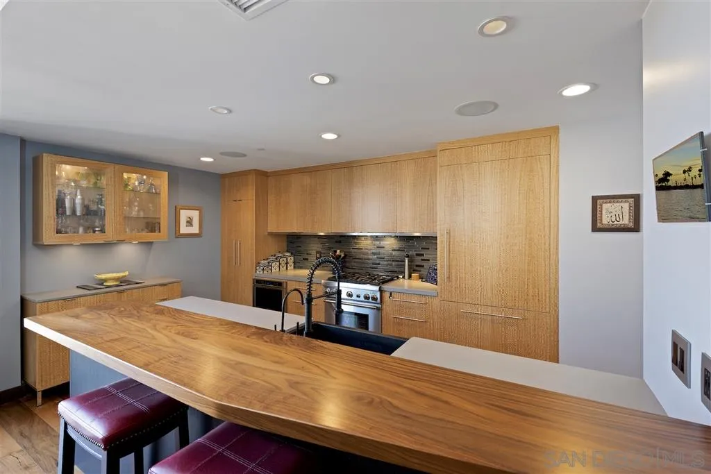 645 Front Street, Unit 2101 San Diego, CA 92101 - Photo 13 of 32 a kitchen with stainless steel appliances granite countertop a sink dishwasher and a refrigerator with wooden floor