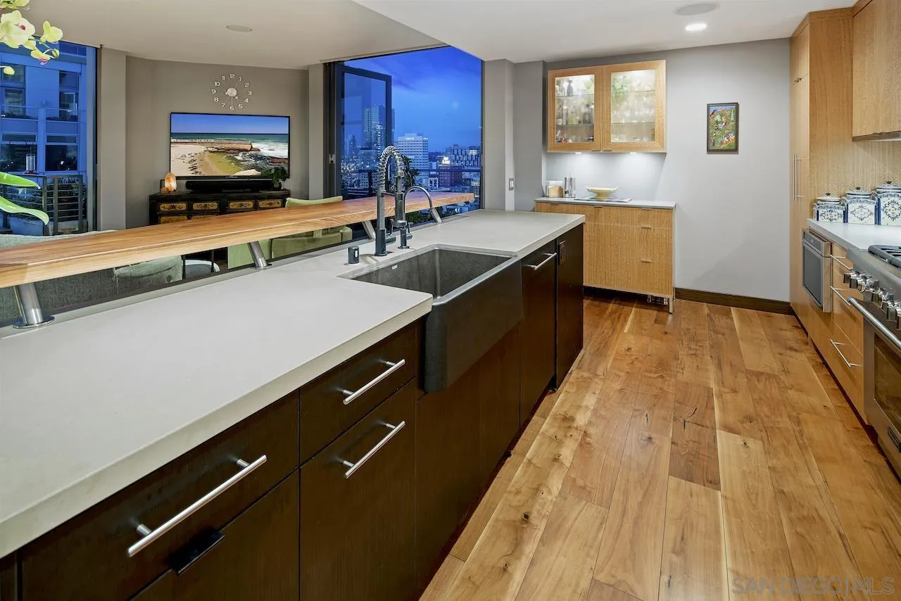 645 Front Street, Unit 2101 San Diego, CA 92101 - Photo 10 of 32 a large kitchen with kitchen island a sink wooden floor and counter space
