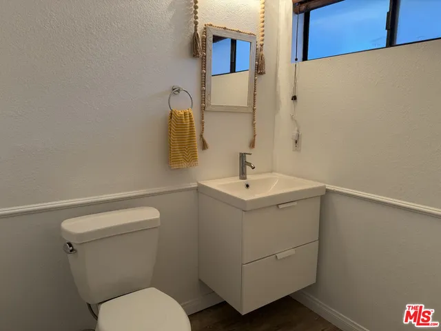 a bathroom with a sink a toilet and mirror