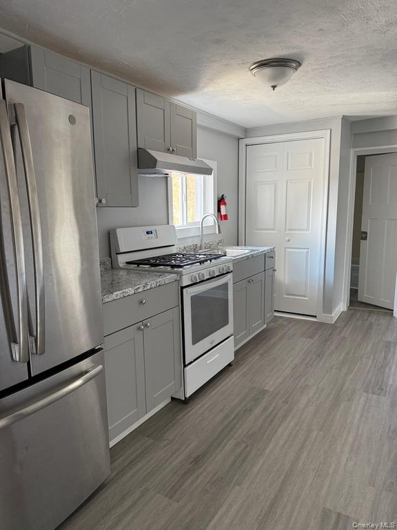 14 Glass Street Port Jervis, NY 12771 - Photo 4 of 11 a kitchen with stainless steel appliances a stove a refrigerator and a sink