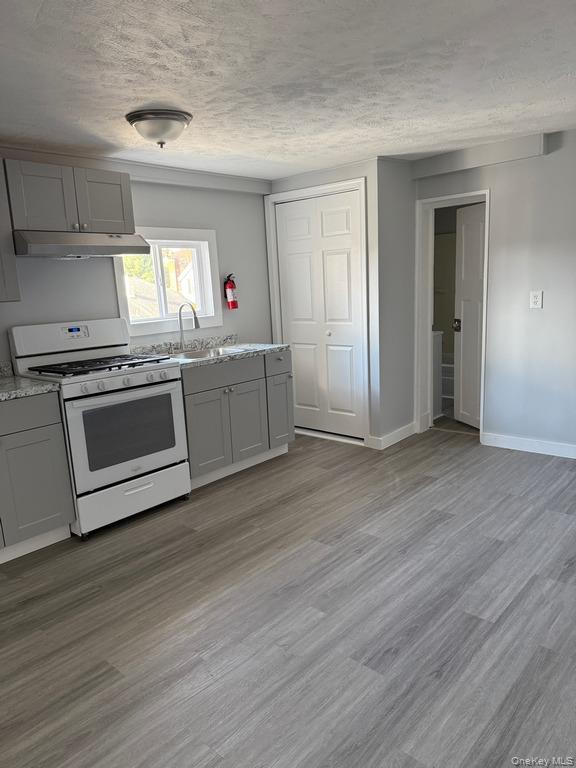 14 Glass Street Port Jervis, NY 12771 - Photo 5 of 11 a kitchen with granite countertop a stove and a wooden floors