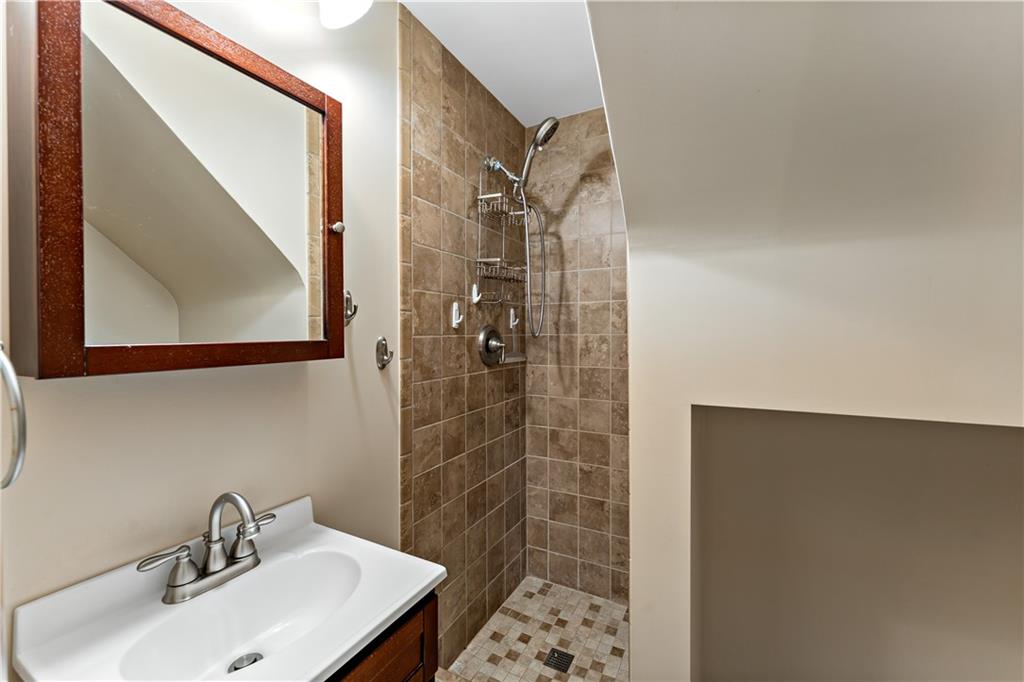 27 Dover Road Irwin, PA 15642 - Photo 26 of 43 a bathroom with a sink a mirror and shower